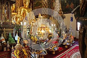 Offerings of flowers and golden Buddha statues decorate a temple (Thailand) photo
