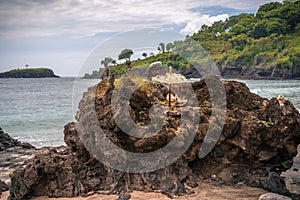 Offerings to the Balinese Hindu Gods and Demons placed on a coastal rock