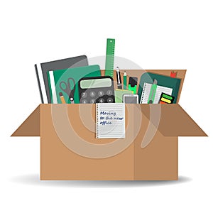 Office accessories in a cardboard box. `Moving to the new office` concept