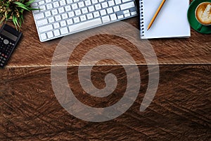 Office accessories laptop, smartphone, notepad, and coffee cup on a wooden table background.