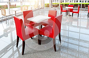 Office bar with red chairs and white tables