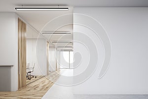 Office with blank wall and row of meeting rooms