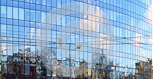 Office building on a city street and reflection of the sky in windows