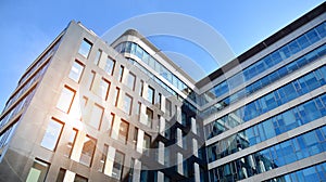 Office building, details of blue glass wall and sun reflections.