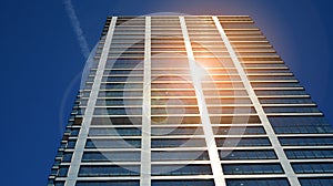 Office building, details of blue glass wall and sun reflections.