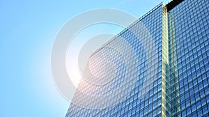 Office building, details of blue glass wall and sun reflections.