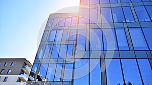 Office building, details of blue glass wall and sun reflections.