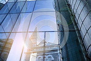 Office building glass facades on a bright sunny day with sunbeams in the blue sky.