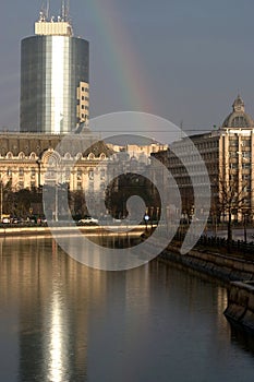 Office building, rainbow and Dambovita river