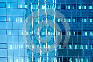 Office building reflected in glass facade of another office building