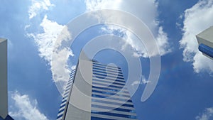 Office building under White clouds and blue sky on the warmest noon in Thailand