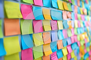 Office bulletin board covered in colorful sticky notes for organization. Concept Home Office