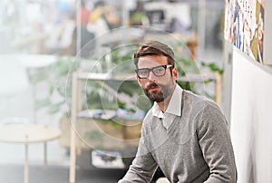 Office, business and portrait of man in creative workspace for career, job and working at startup company. Professional