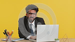 Office businessman hiding behind laptop computer making funny silly face fooling around, disrespect