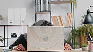 Office businessman hiding behind laptop computer making funny silly face fooling around, disrespect