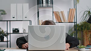 Office businesswoman hiding behind laptop computer making funny silly face fooling around disrespect