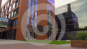 Office center complex, modern brickwork and large glass windows with reflections