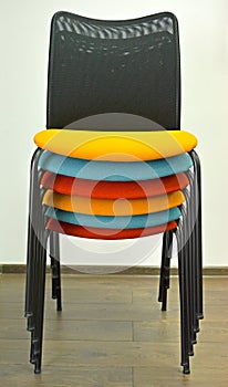 Office chairs are put with color semi-soft seats in a stack