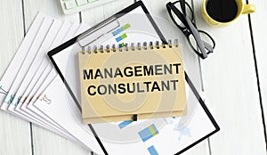 Office desk with charts with text: Management consultant