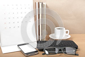 office desk : coffee with phone,stack of book,eyeglasses,wallet,calendar