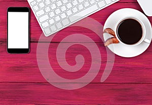 Office desk with copy space. Digital devices wireless keyboard, mouse smartphone with empty screen on pink wooden table, top view.