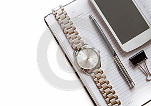 Office Desk with a diary, smartphone, pen on a Notepad, men`s wrist watch. Top view with copy space on a white background