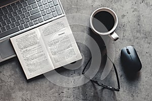 The office desk flat lay view with laptop, mouse, tree, paper clip, coffee cup, notebook, pencil