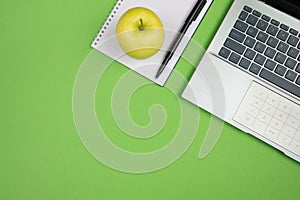 office desk with laptop calculator and other office supplies on isolated green background with copy space