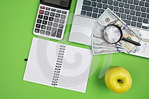 office desk with laptop calculator and other office supplies on isolated green background with copy space