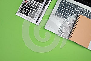 office desk with laptop calculator and other office supplies on isolated green background with copy space