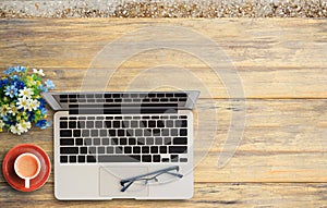 Office desk with laptop computer and coffee cup on wooden.