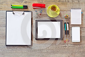 Office desk mock up template with tablet, smart phone, notebook and cup of coffee. View from above with copy space