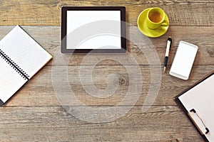 Office desk mock up template with tablet, smart phone, notebook and cup of coffee. View from above with copy space