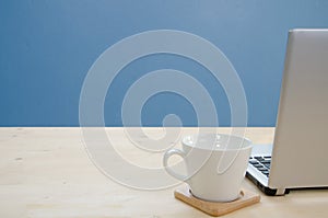 Office desk with notebook and coffee cup.