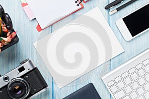 Office desk with supplies, camera and blank card