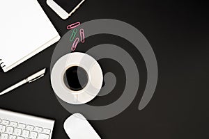 Office desk table with computer, phone, white mouse, silver pen, pink and green paper clip and black coffee cup. Business desk ta