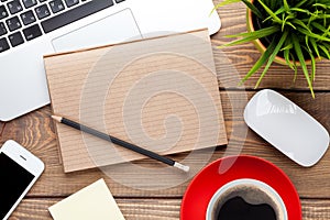 Office desk table with computer, supplies, coffee cup and flower