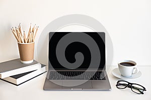 Office desk table with computer, supplies, flower and coffee cup. Top view with copy space.