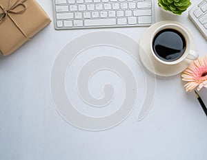 Office desk table with computer, supplies, flower and coffee cup. Top view with copy space