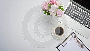 Office desk table with computer, supplies, flower and coffee cup. Top view with copy space