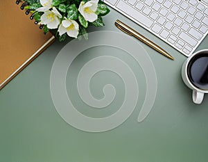 Office desk table with computer, supplies, flower and coffee cup. Top view with copy space