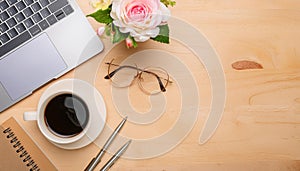 Office desk table with computer, supplies, flower and coffee cup. Top view with copy space