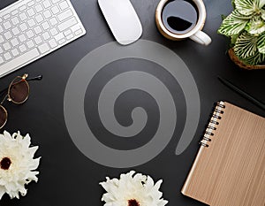 Office desk table with computer, supplies, flower and coffee cup. Top view with copy space