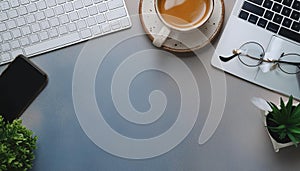 Office desk table with computer, supplies, flower and coffee cup. Top view with copy space