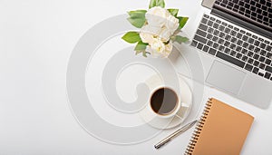 Office desk table with computer, supplies, flower and coffee cup. Top view with copy space