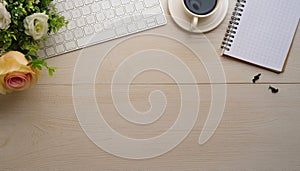 Office desk table with computer, supplies, flower and coffee cup. Top view with copy space