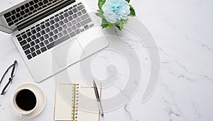 Office desk table with computer, supplies, flower and coffee cup. Top view with copy space