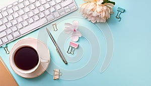 Office desk table with computer, supplies, flower and coffee cup. Top view with copy space