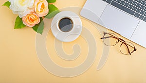 Office desk table with computer, supplies, flower and coffee cup. Top view with copy space