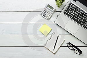 Office desk table with computer, supplies, flower. Top view. Copy space for text